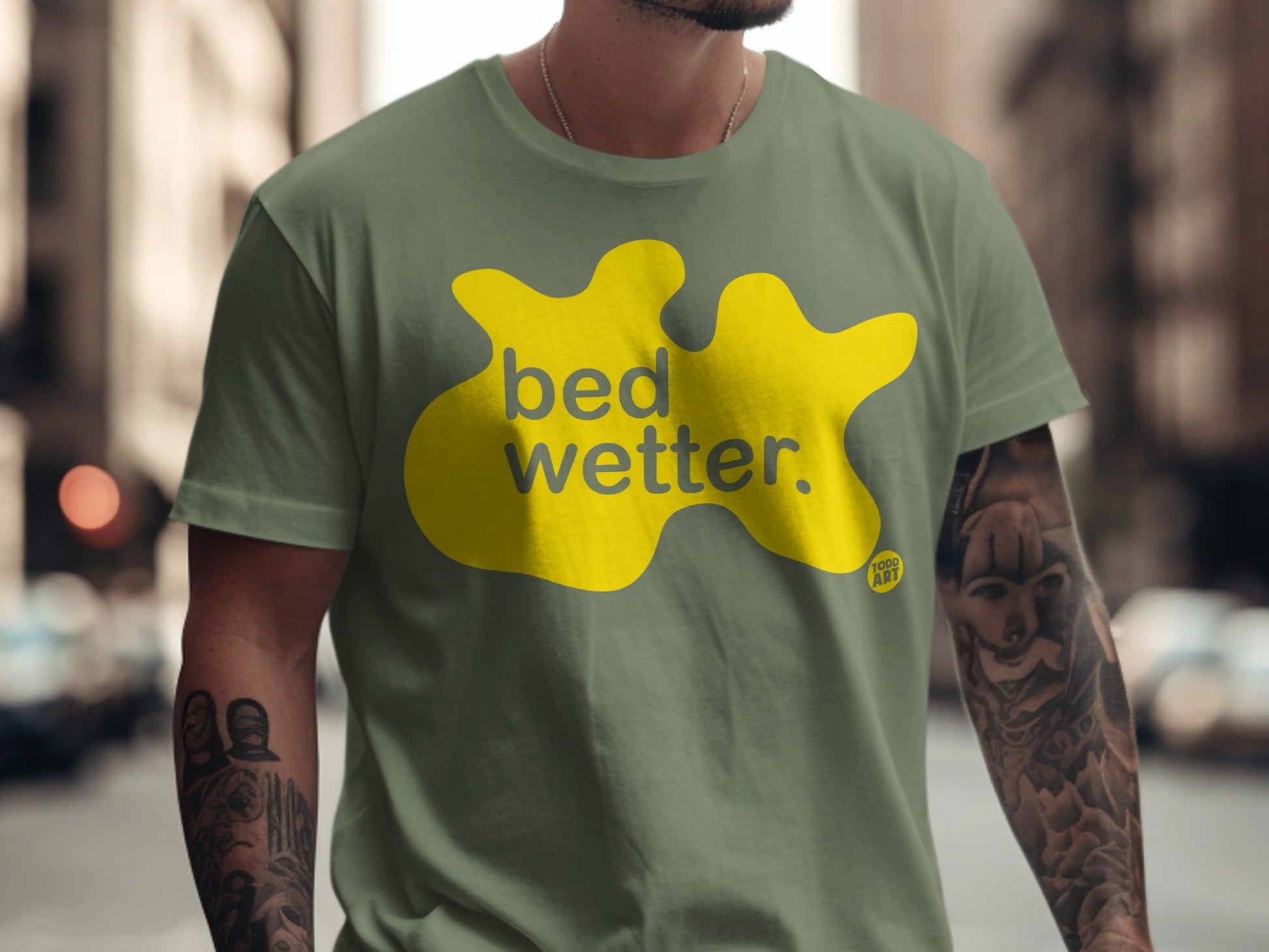Green t-shirt with yellow "bed wetter" graphic and "cool art" logo.