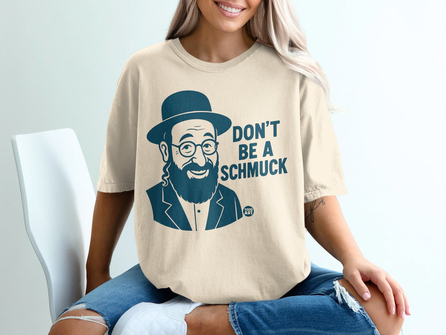 T-shirt with text "DON'T BE A SCHMUCK" and a man in a hat.