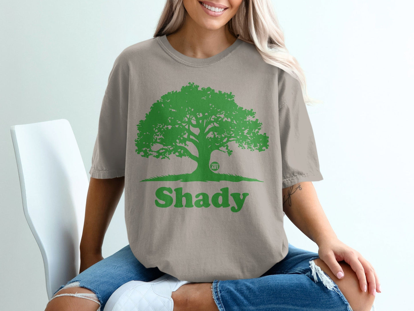 Tan t-shirt with green tree graphic and "Shady" text.