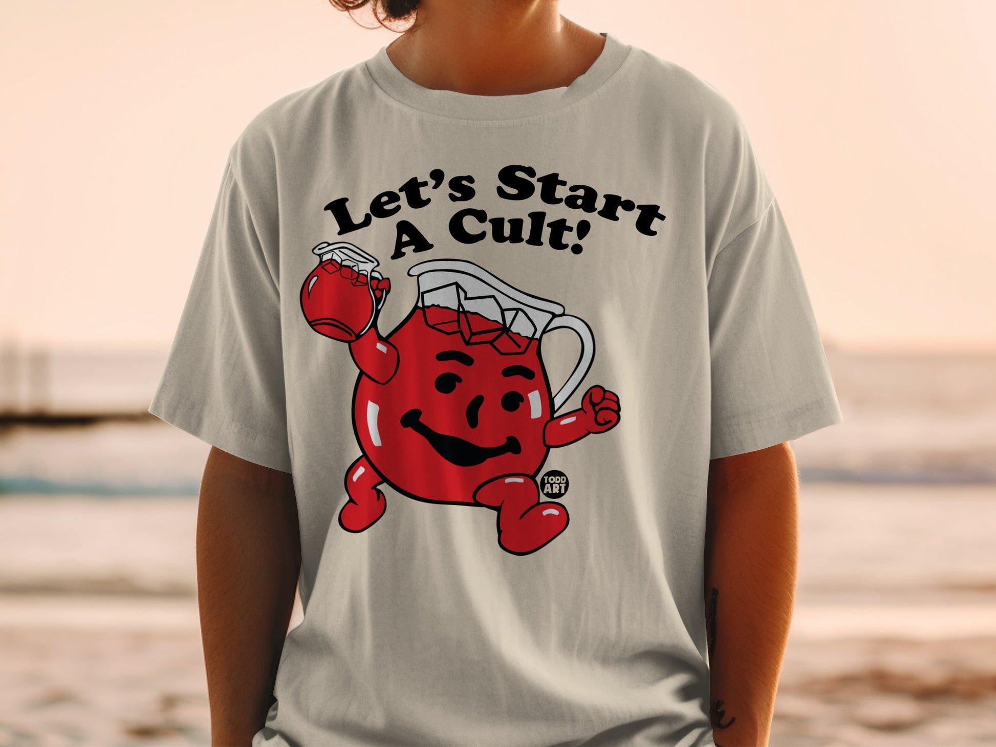 Light grey t-shirt with cartoon Kool-Aid man and text "Let's Start A Cult!".