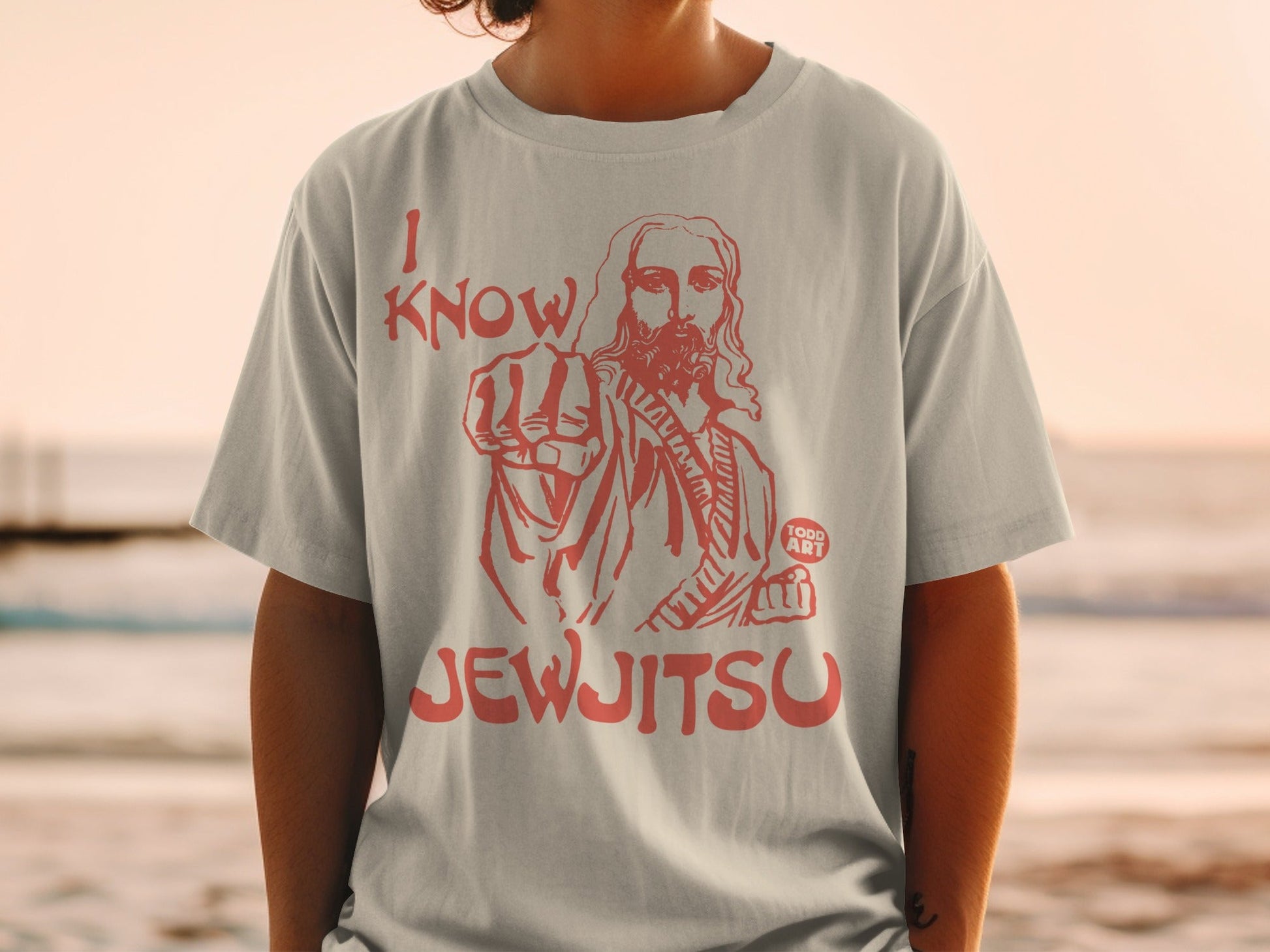 Light grey t-shirt with red graphic of Jesus pointing and text "I KNOW JEWJITSU".