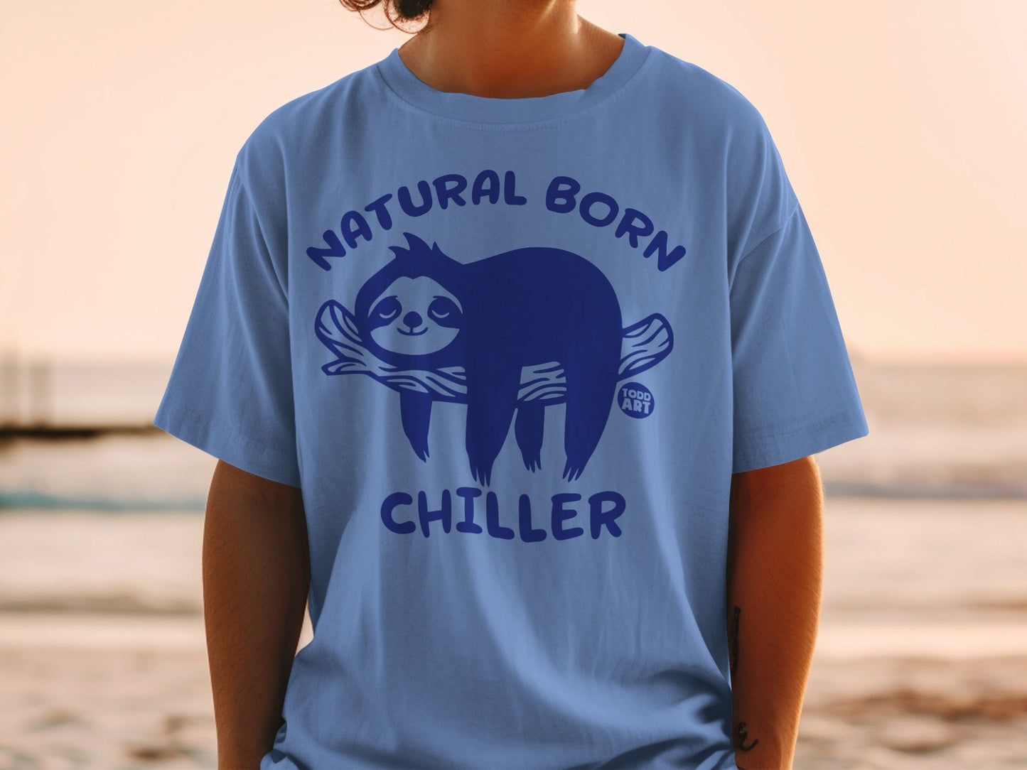Blue t-shirt with "Natural Born Chiller" text and a sloth on a branch.