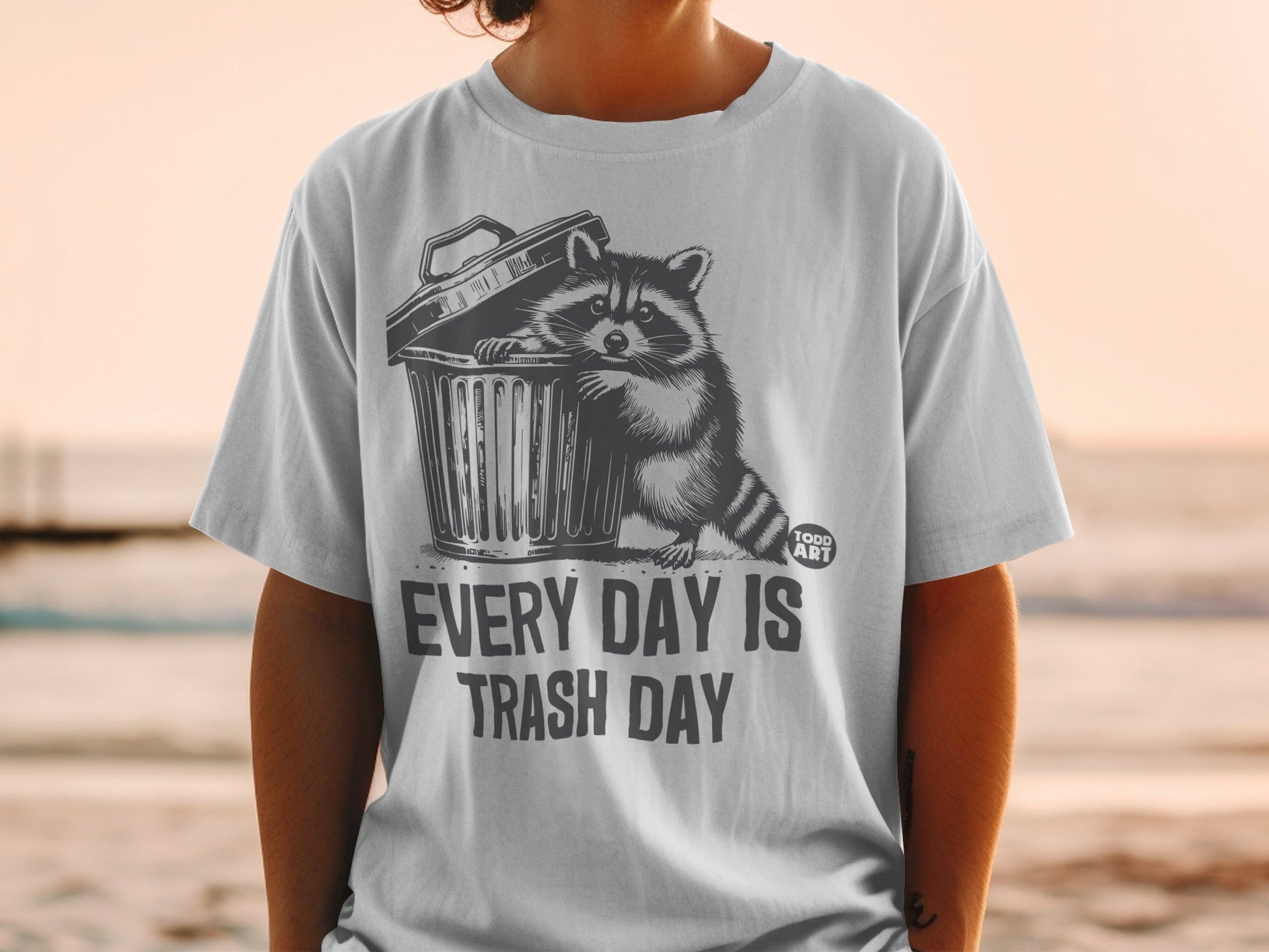 T-shirt with raccoon emerging from trash can, reads "Every Day Is Trash Day".