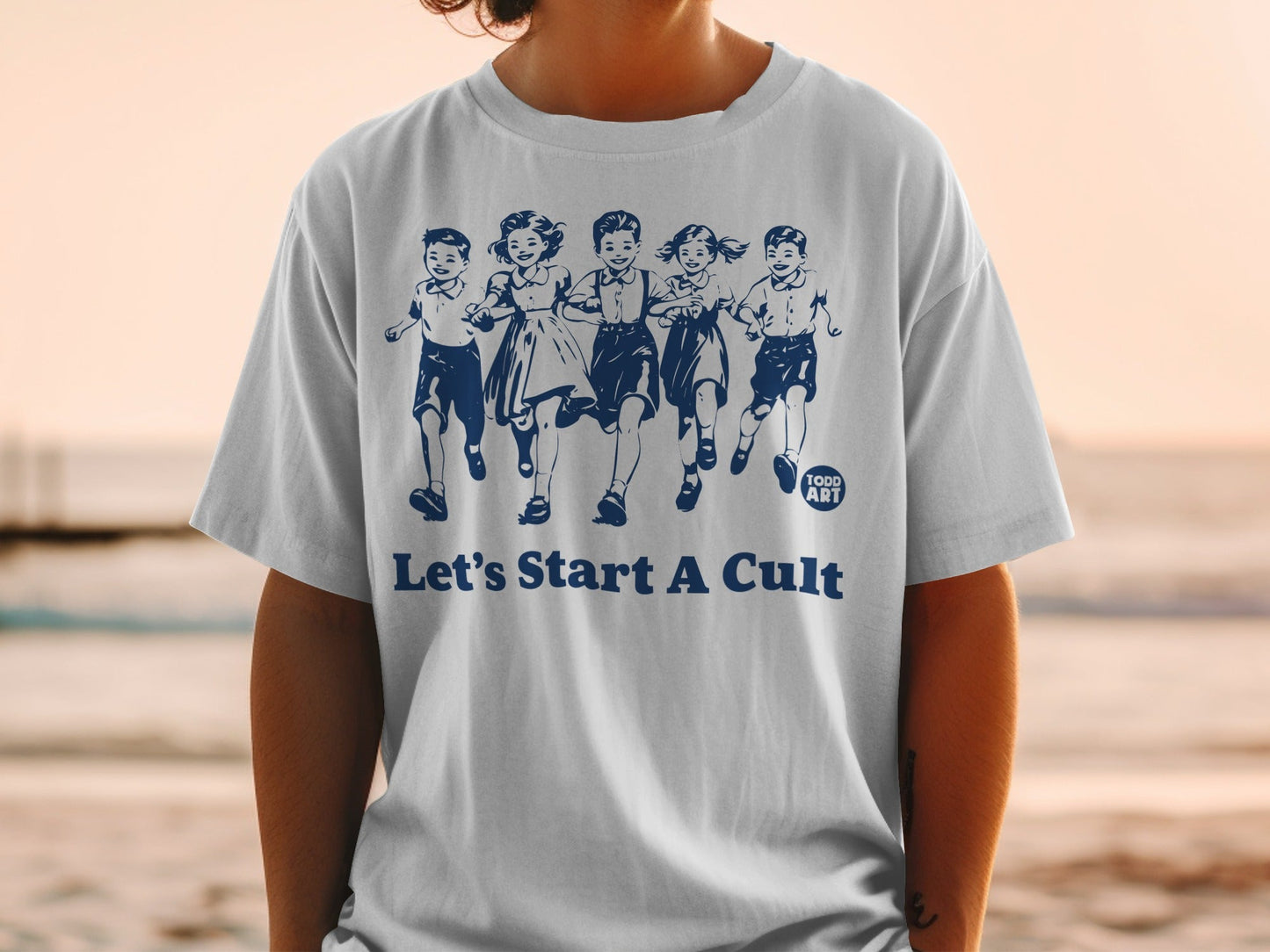 White t-shirt with blue graphic of running children and text "Let's Start A Cult".