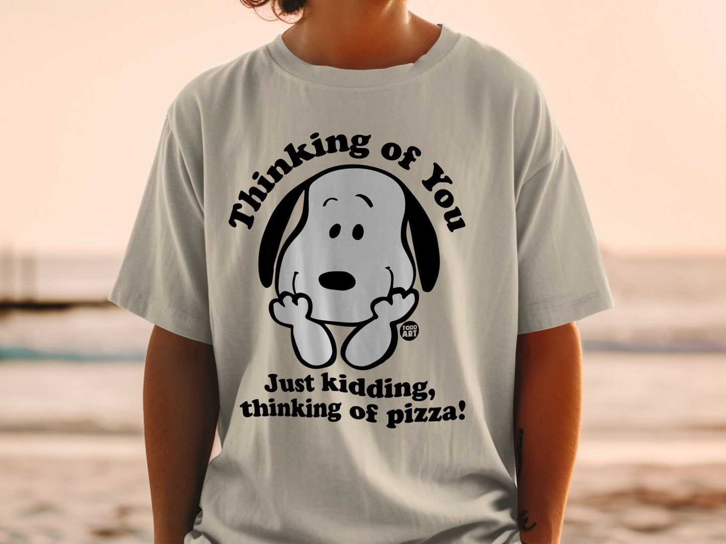 T-shirt with Snoopy graphic and "Just kidding, thinking of pizza!" text.