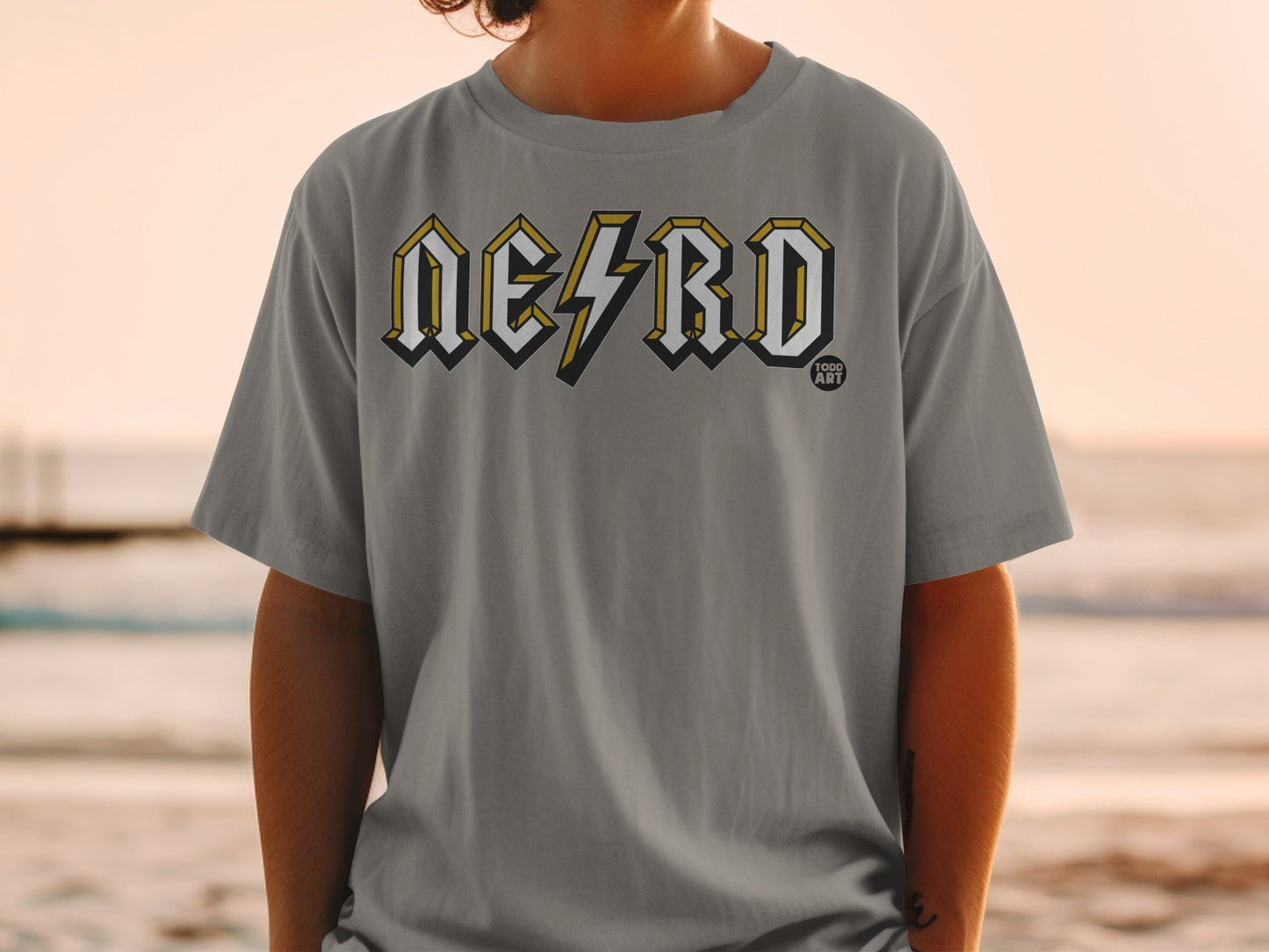 Grey t-shirt with "NERD" logo in yellow and black, person wearing it.