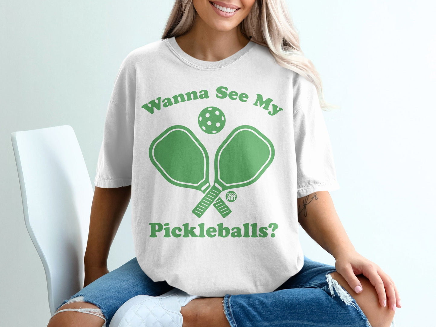 White t-shirt with green pickleball paddles and text "Wanna See My Pickleballs?".