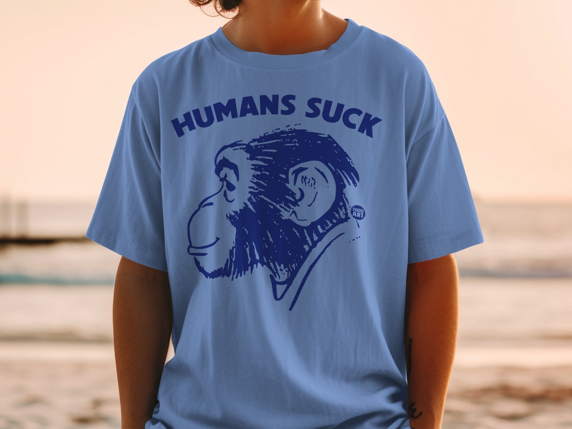 Blue t-shirt with "HUMANS SUCK" and a monkey illustration.