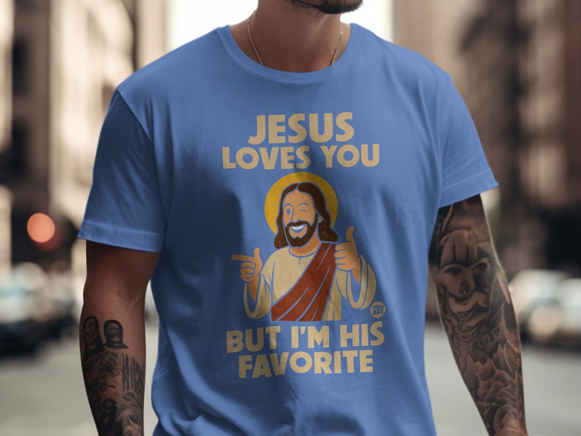 Blue t-shirt with "Jesus loves you but I'm his favorite" and cartoon Jesus.