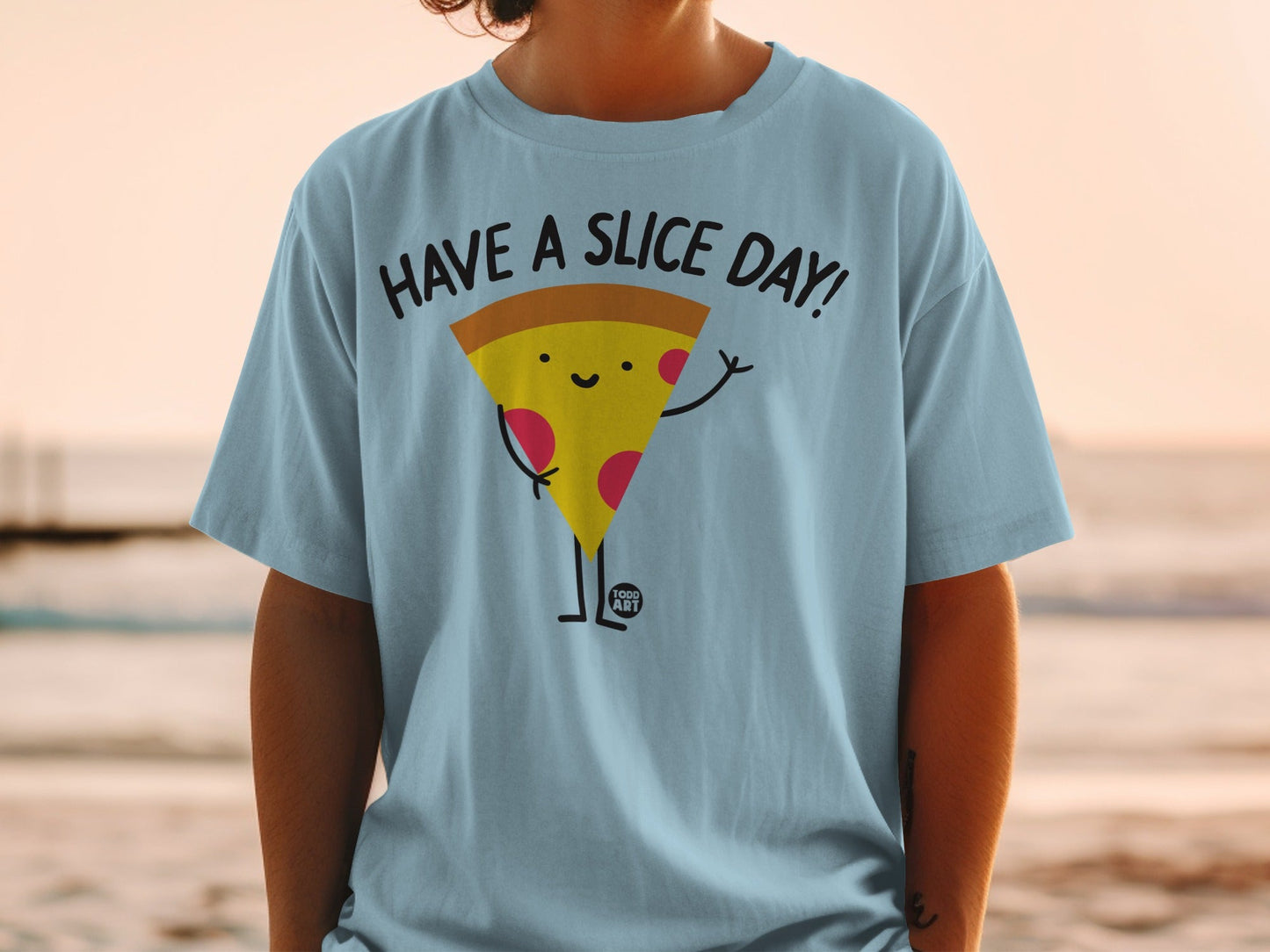 Light blue t-shirt with a cartoon slice of pizza saying "Have a Slice Day!".