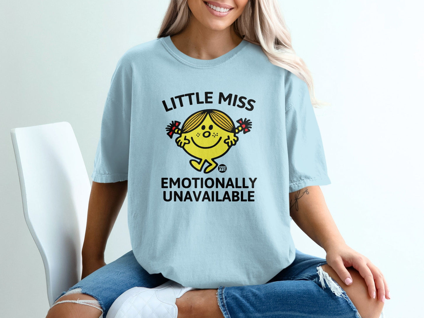 Light blue t-shirt with "Little Miss Emotionally Unavailable" text and graphic.