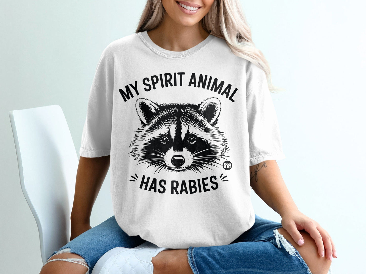 White t-shirt with raccoon illustration and "MY SPIRIT ANIMAL HAS RABIES" text.