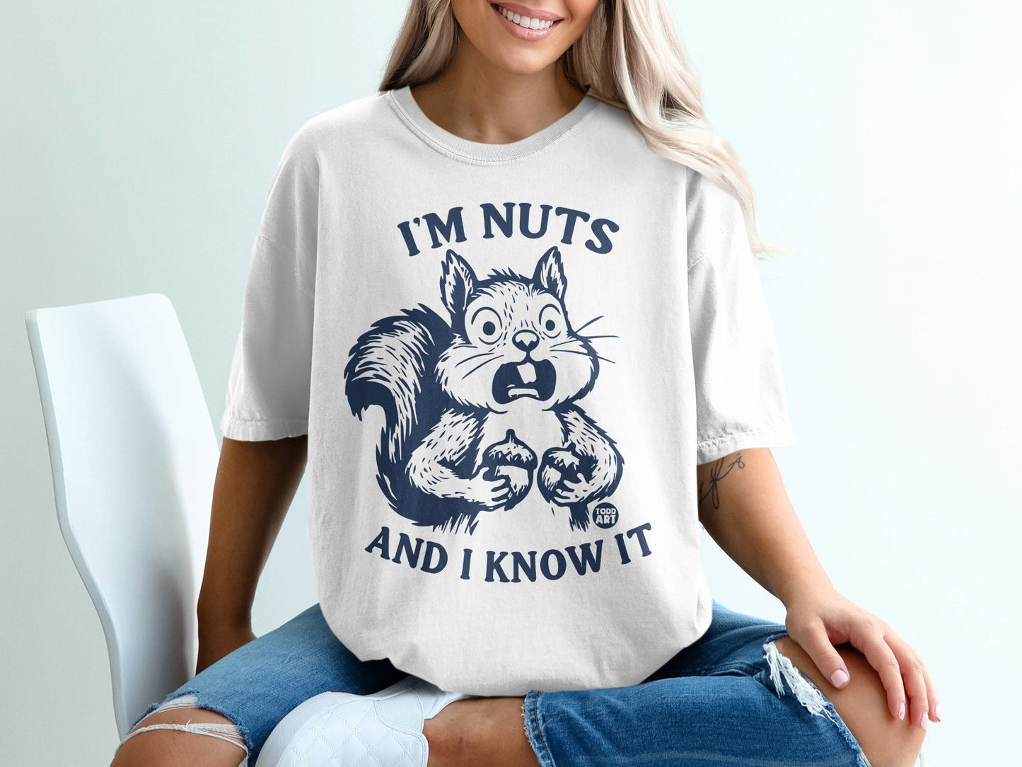 White t-shirt with a surprised squirrel holding nuts and the text "I'm nuts and I know it".