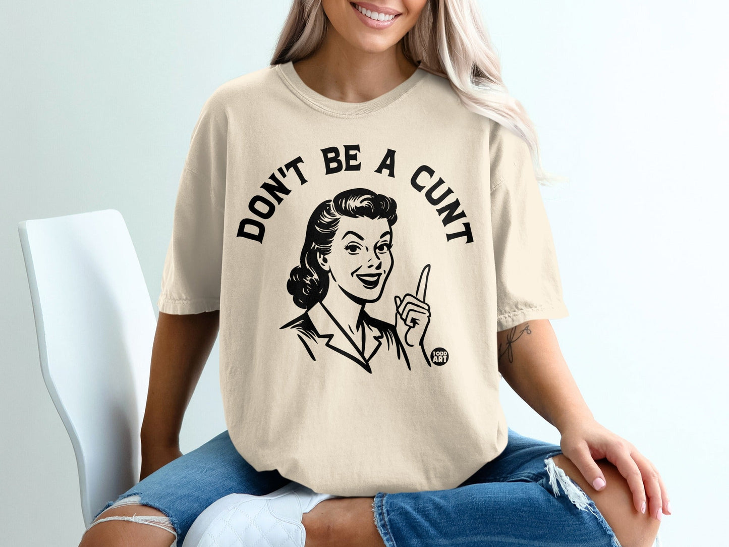 Cream t-shirt with "DON'T BE A CUNT" slogan and retro graphic.