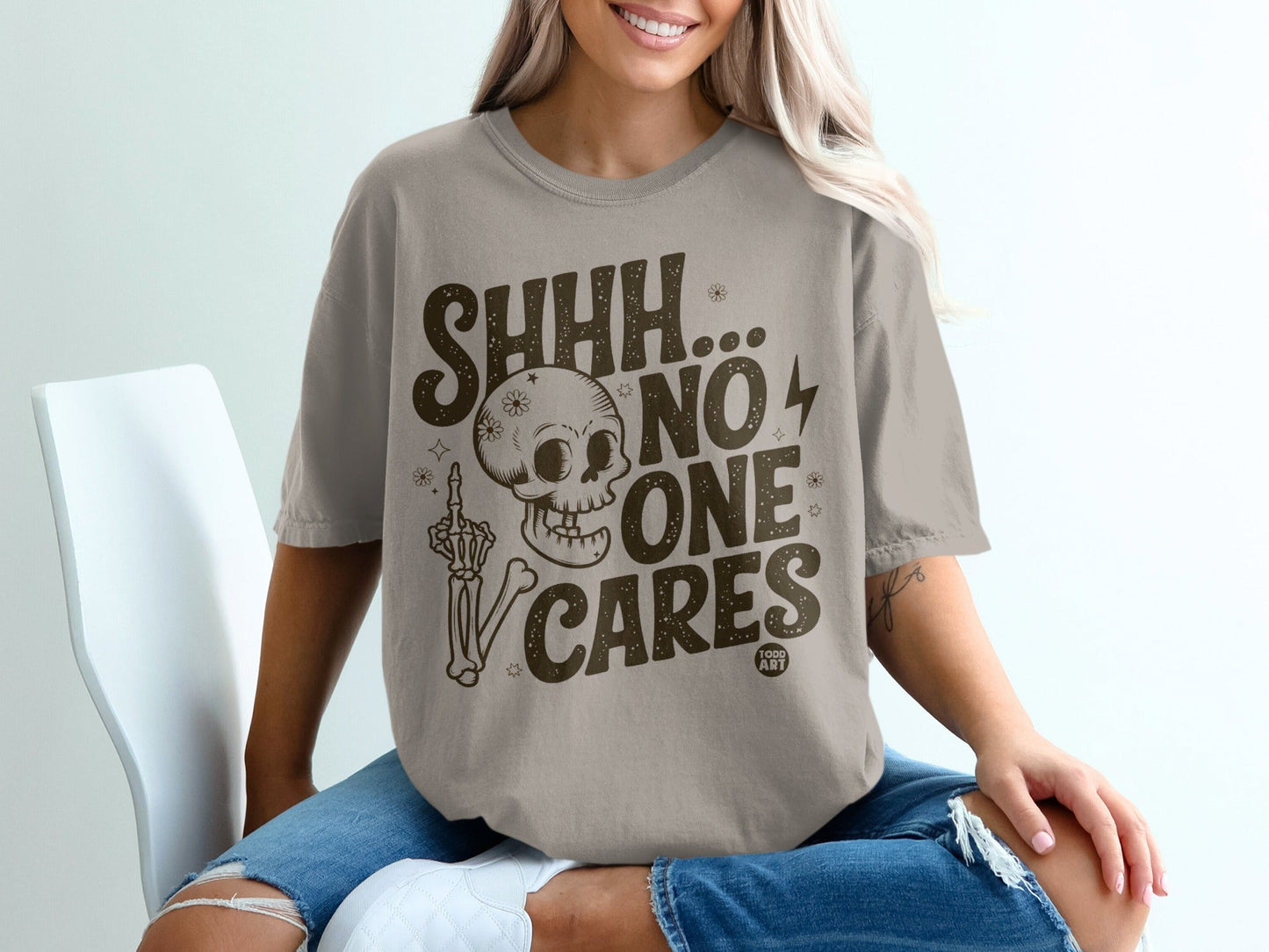 T-shirt with "SHHH... NO ONE CARES" text and a skeleton flipping the bird.