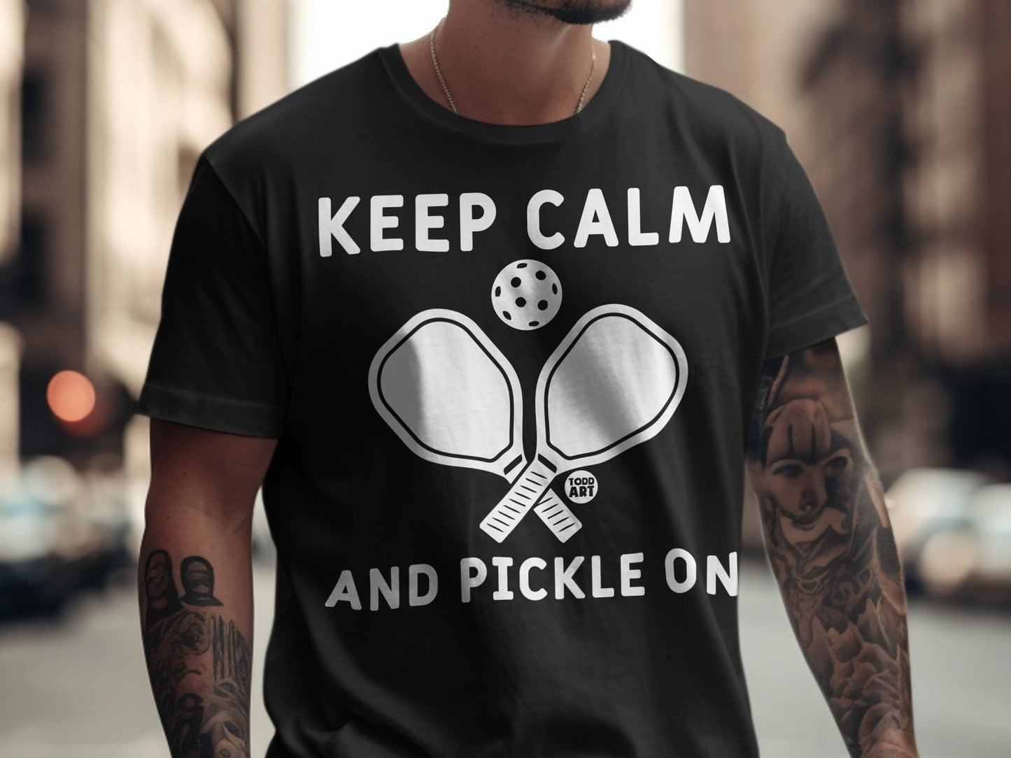 Black t-shirt with "Keep Calm and Pickle On" text and pickleball paddles graphic.