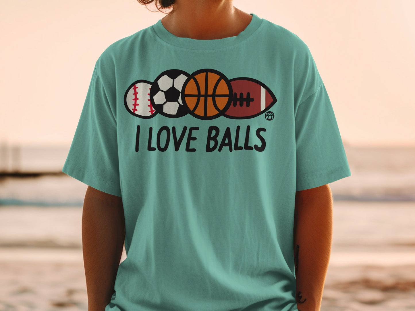 Teal t-shirt with text "I LOVE BALLS" and sports balls.