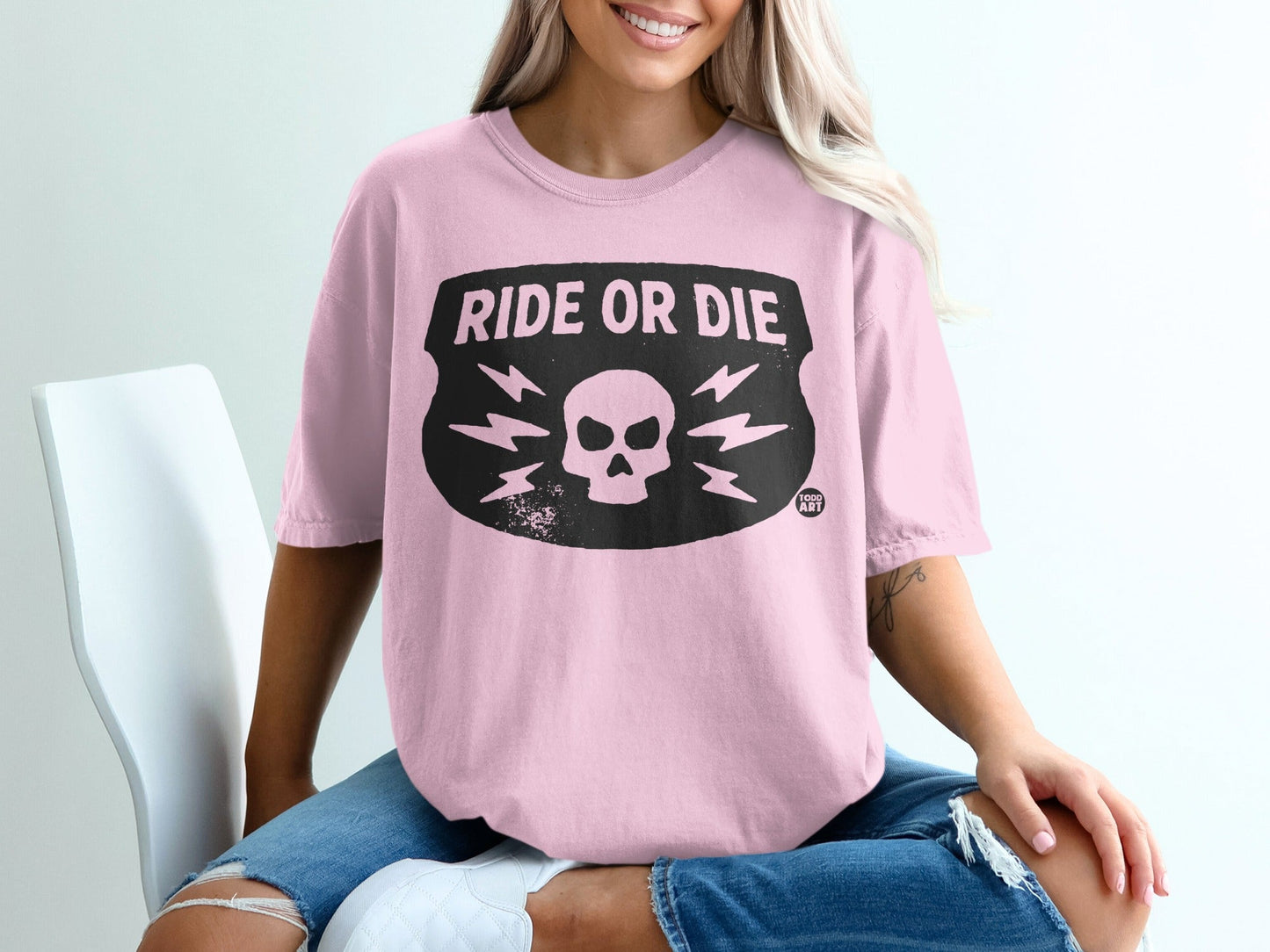 Pink t-shirt with black "RIDE OR DIE" shield graphic and lightning bolts.