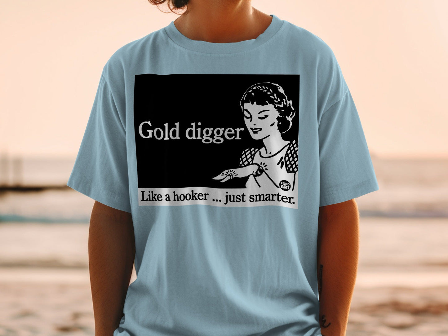 Light blue t-shirt with "Gold Digger Like a hooker... just smarter." text and illustration.
