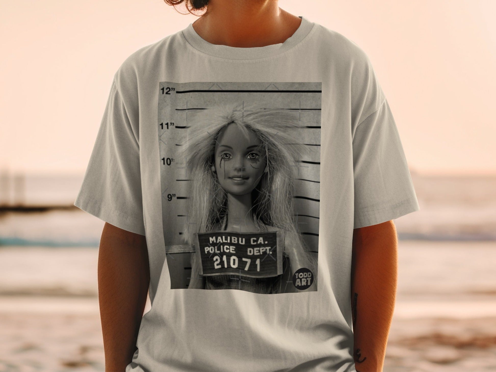 T-shirt with a mugshot of a blonde doll with "MALIBU CA. POLICE DEPT."