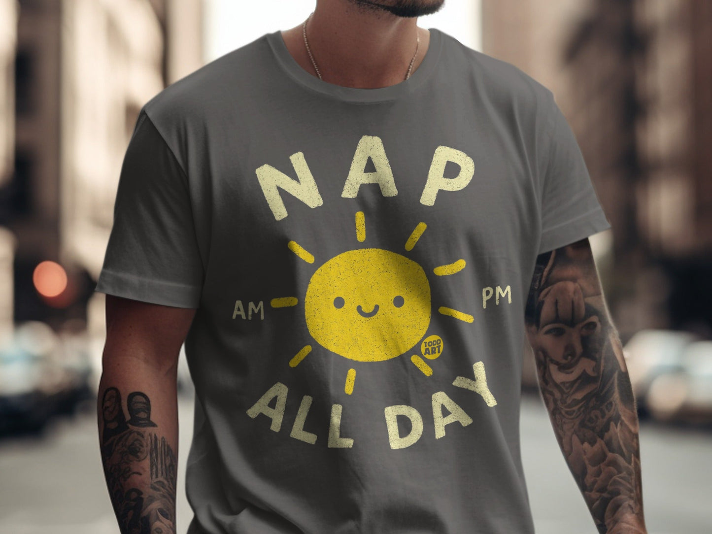 Grey t-shirt with smiling sun graphic and text "NAP AM PM ALL DAY".
