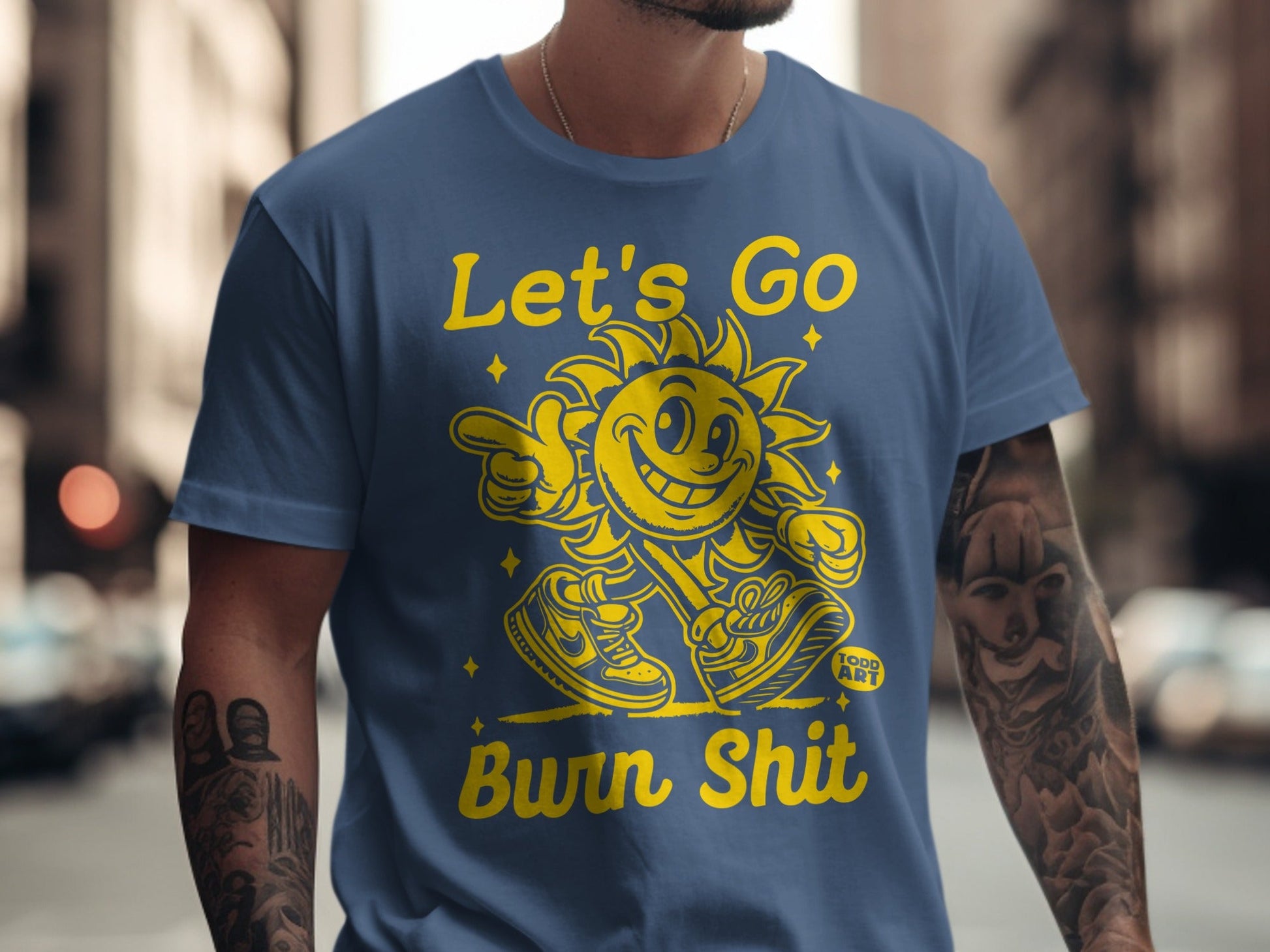 Blue t-shirt with cartoon sun graphic and "Let's Go Burn Shit" text.