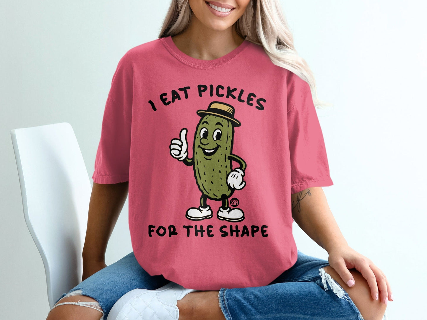 T-shirt with cartoon pickle giving a thumbs up and text "I eat pickles for the shape".