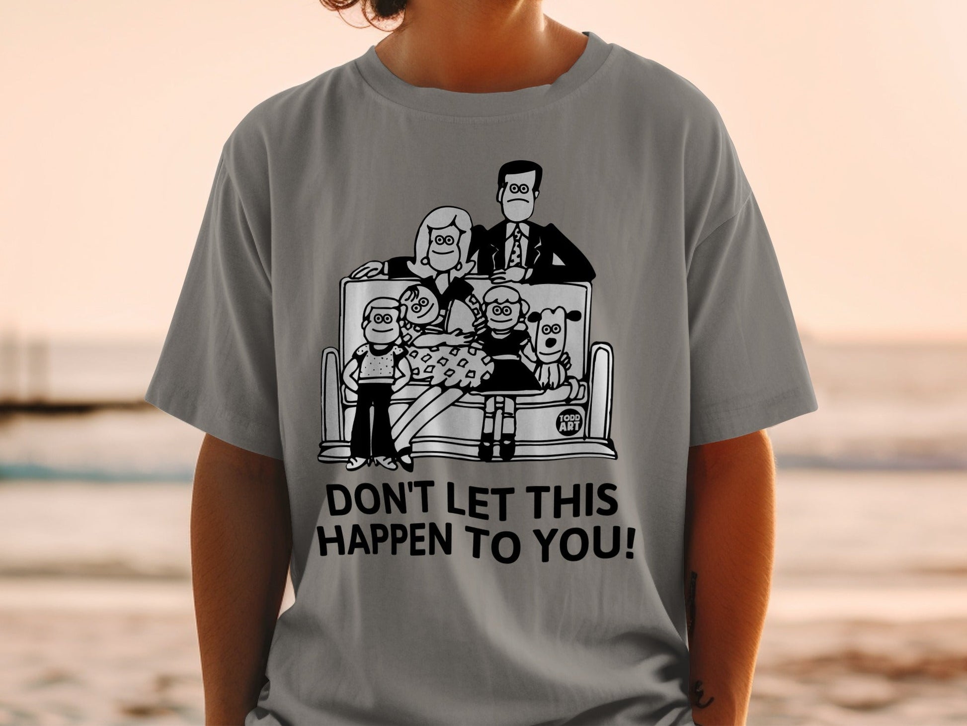T-shirt with cartoon family and dogs, text "DON'T LET THIS HAPPEN TO YOU!".