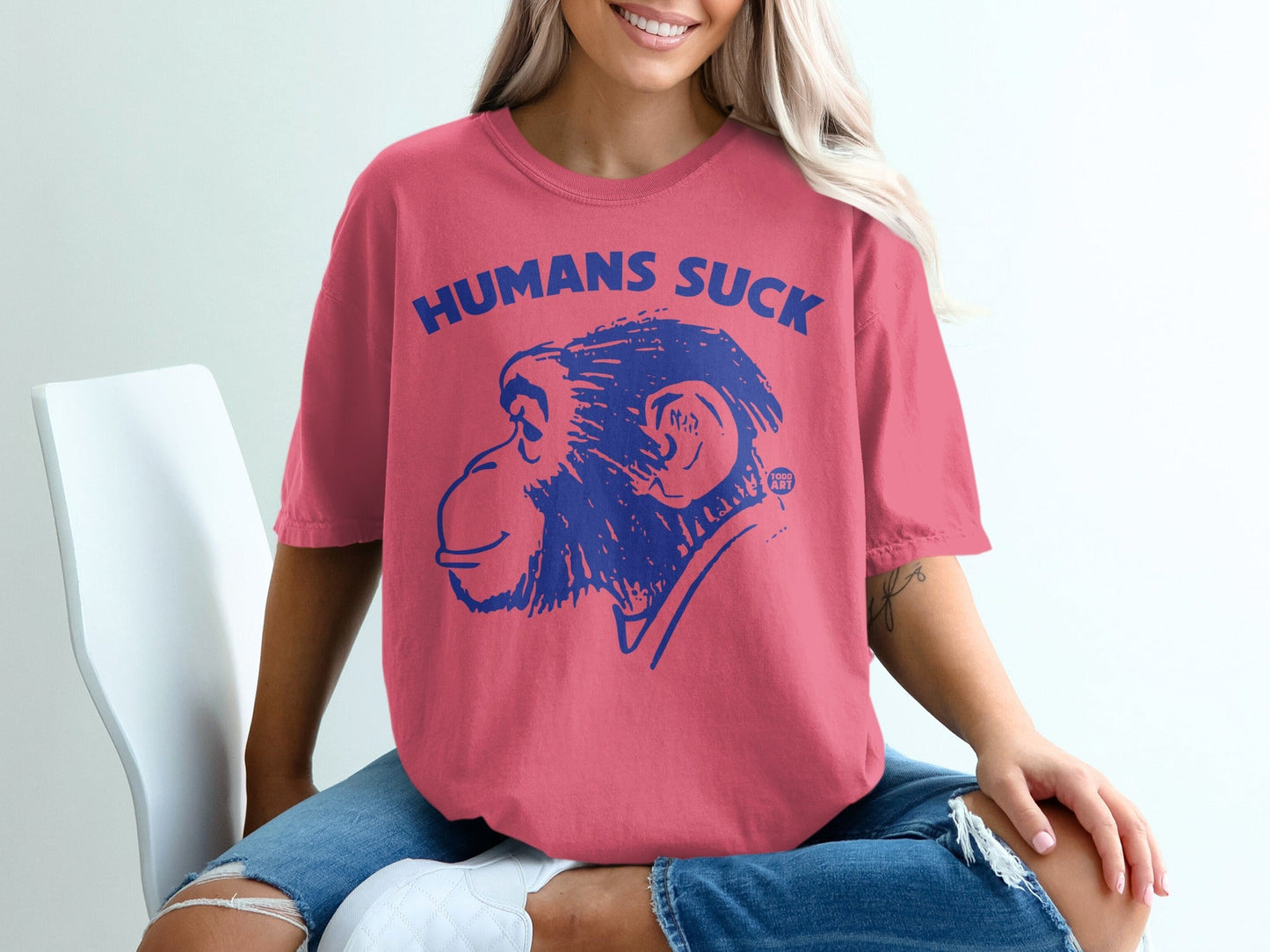 Pink t-shirt with blue "HUMANS SUCK" text and monkey graphic.