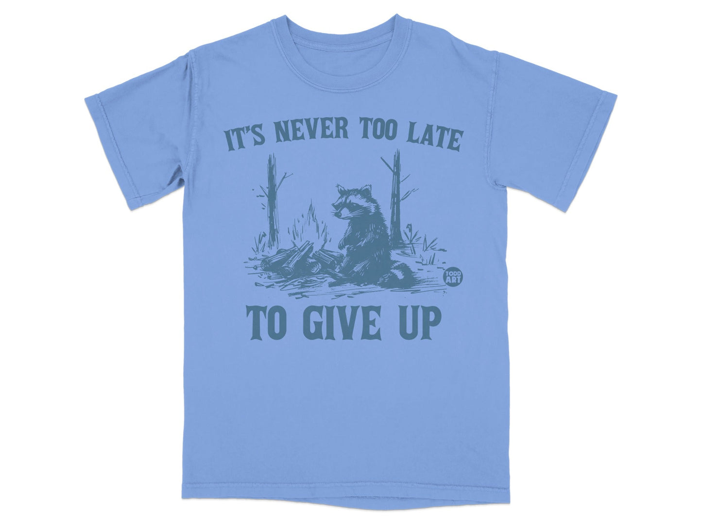 Light blue t-shirt with raccoon graphic and "It's never too late to give up" text.