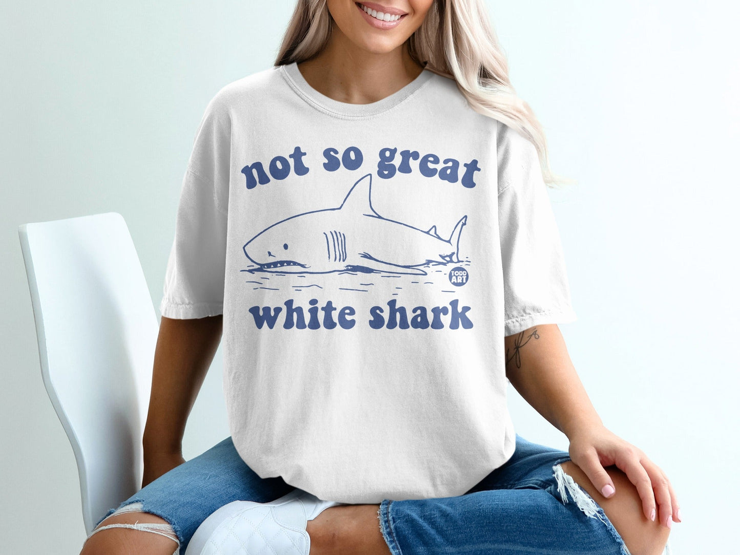 White t-shirt with a cartoon great white shark and "not so great white shark" text.