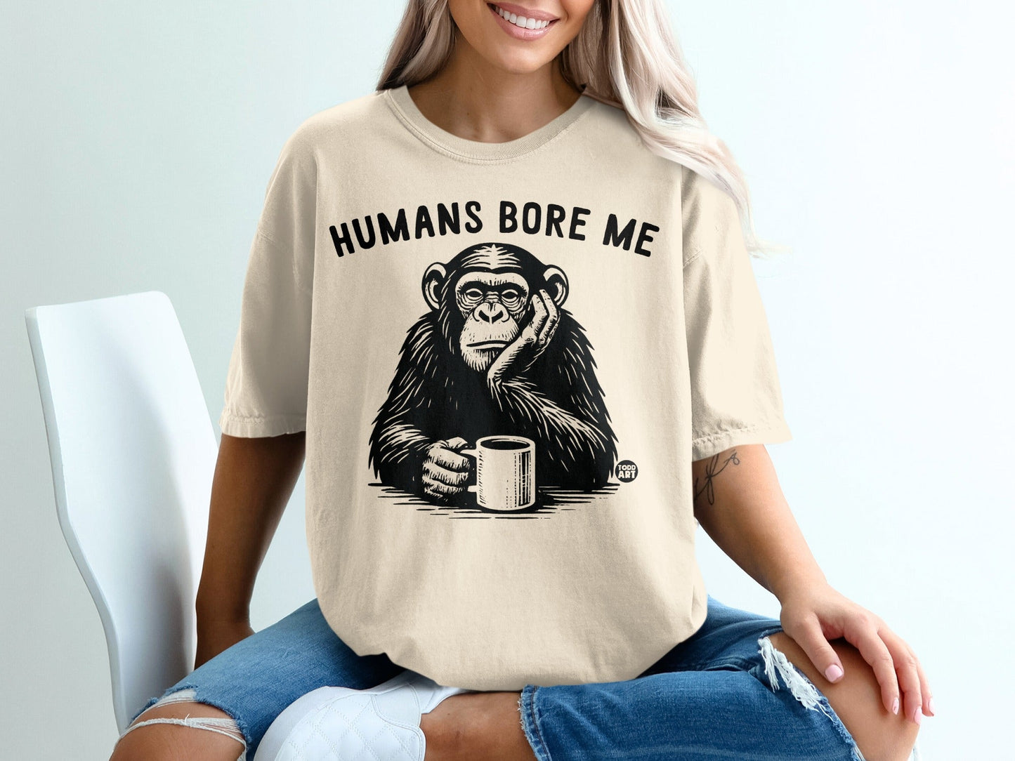 Chimpanzee with "Humans Bore Me" text on a cream t-shirt.