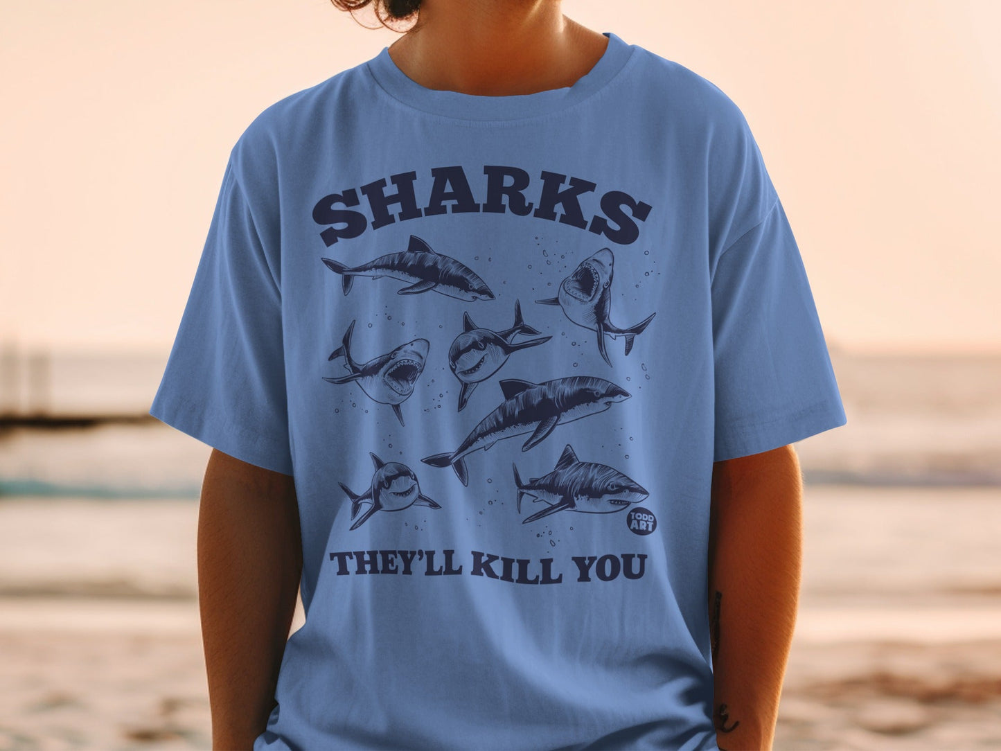 Blue t-shirt with sharks and "SHARKS THEY'LL KILL YOU" text.