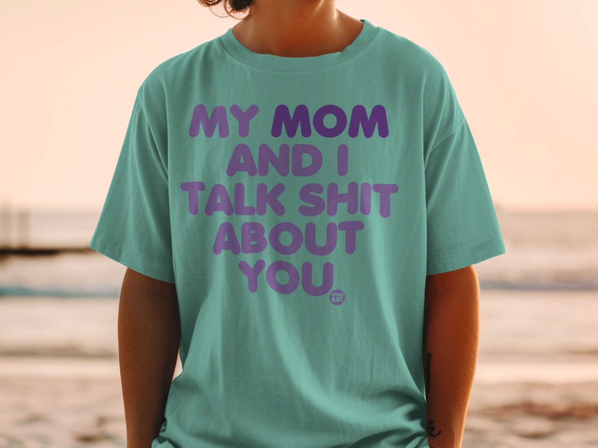 Teal t-shirt with purple text reading "My Mom and I Talk Shit About You".