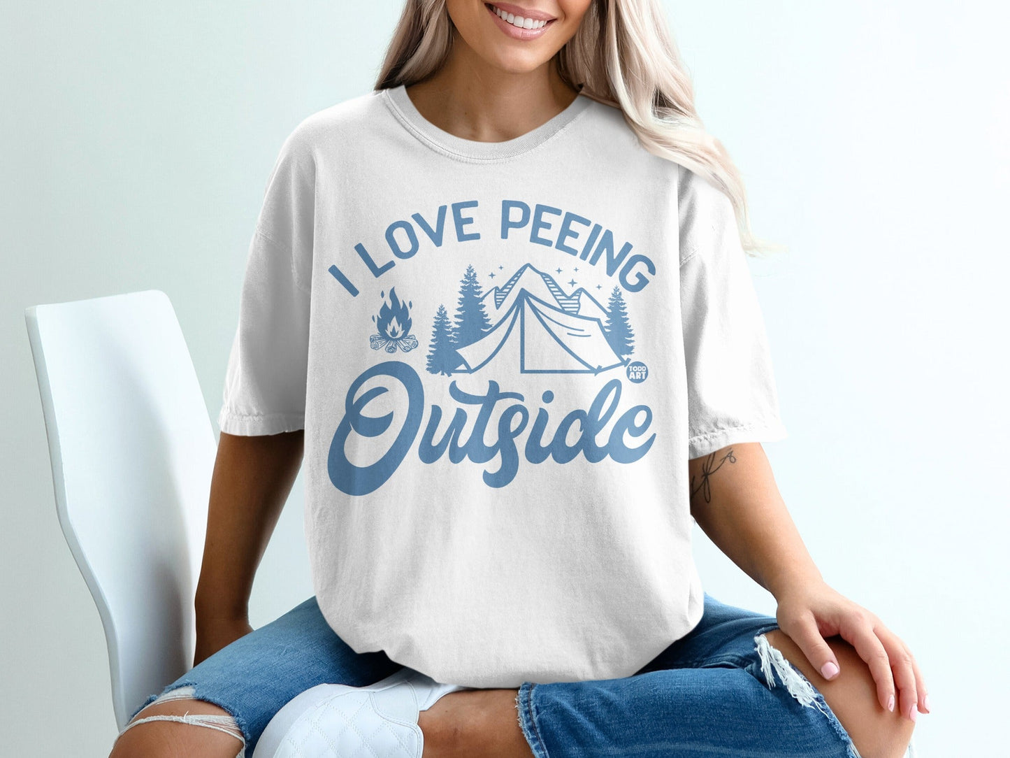 White t-shirt with blue text and graphics: "I LOVE PEeing Outside"