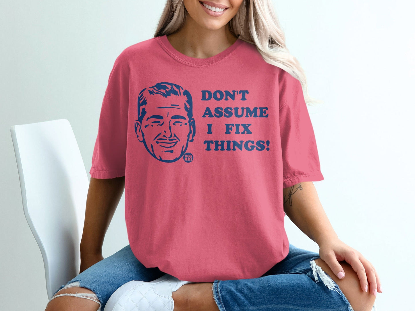 Pink t-shirt with blue text: "DON'T ASSUME I FIX THINGS!"