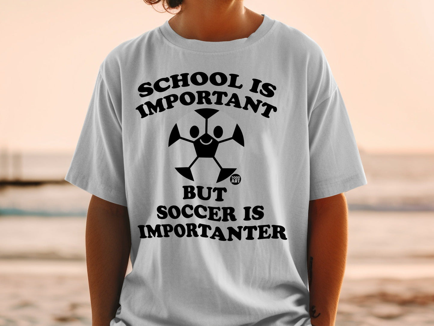 T-shirt with "School is important but soccer is importanter" text and soccer ball graphic.