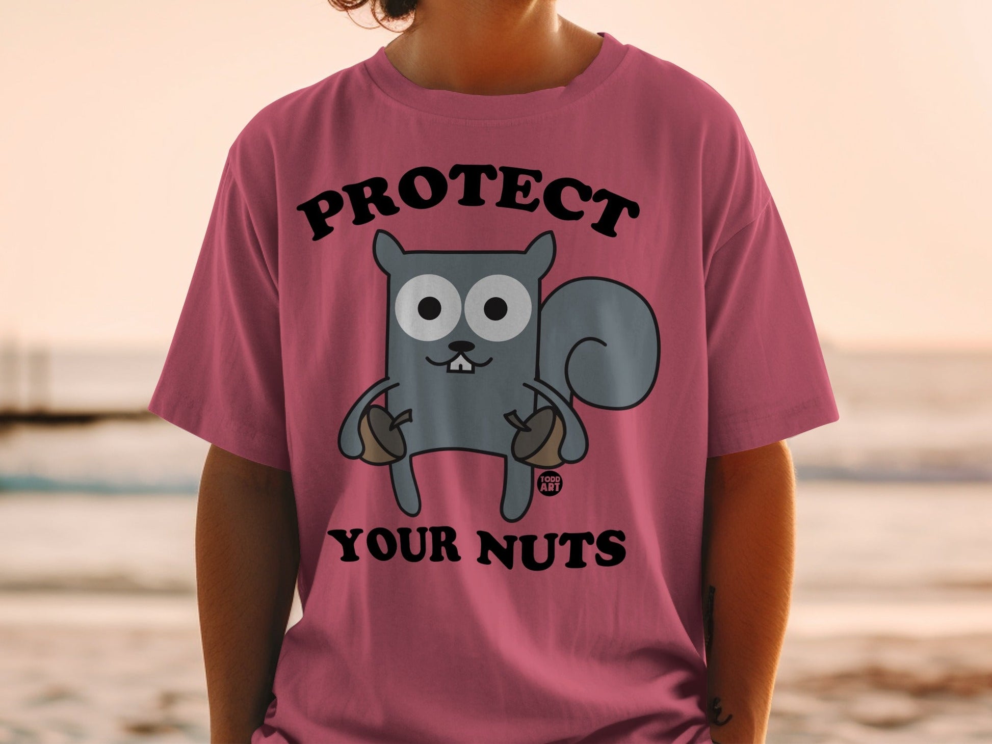 T-shirt with cartoon squirrel holding acorns and text "PROTECT YOUR NUTS".