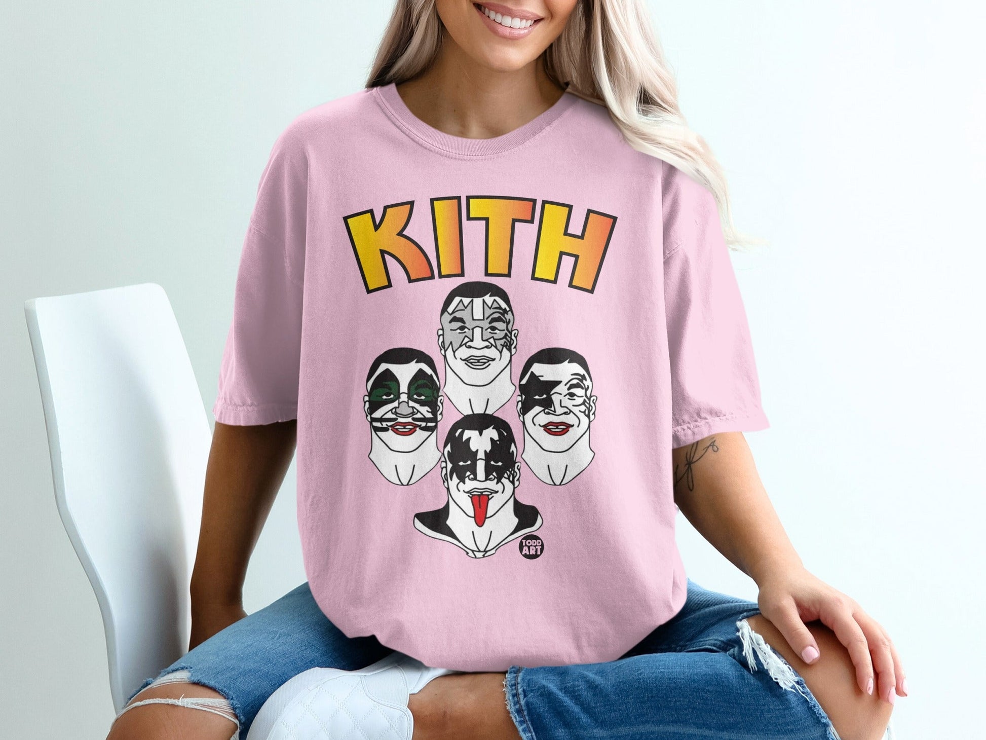 Pink t-shirt featuring the KITH logo and cartoon faces of KISS band members.