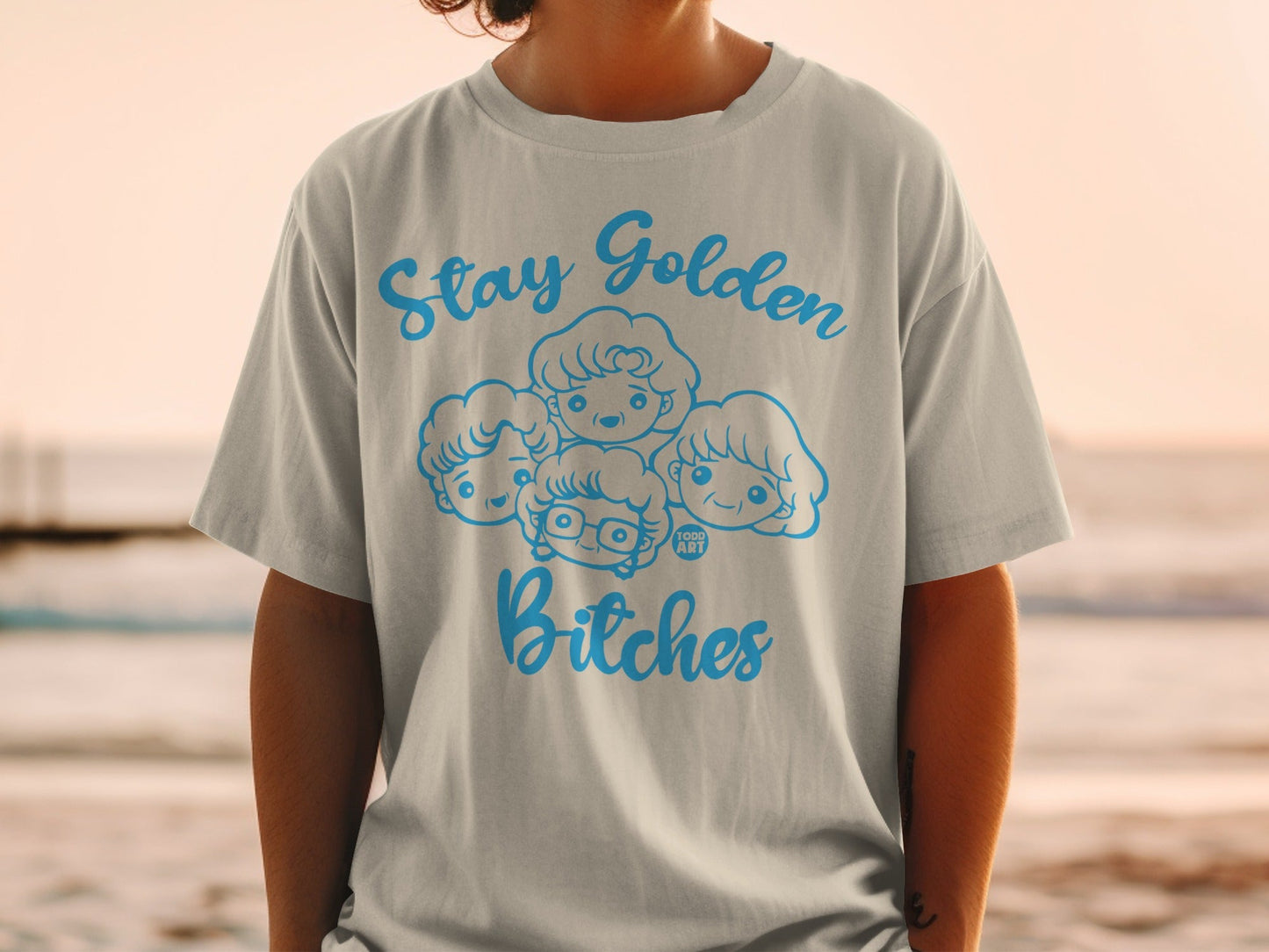 Light gray t-shirt with "Stay Golden Bitches" and cartoon heads of four women.