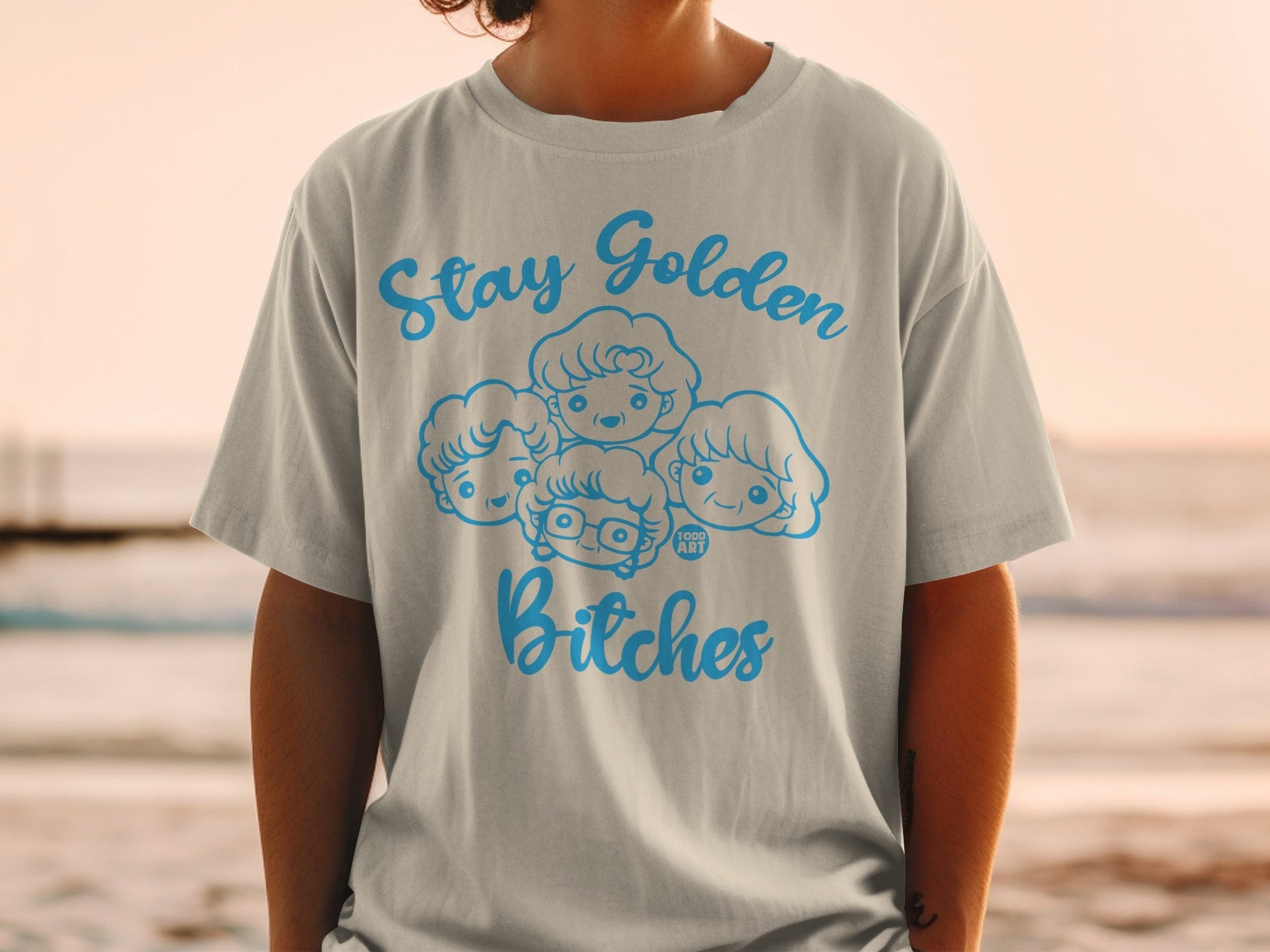 Light gray t-shirt with "Stay Golden Bitches" and cartoon heads of four women.