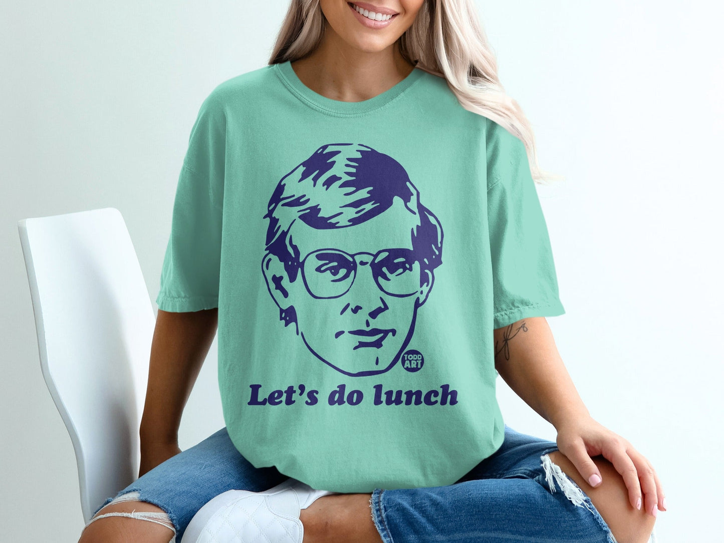 Mint t-shirt with a purple graphic of a man's face and "Let's do lunch" text.