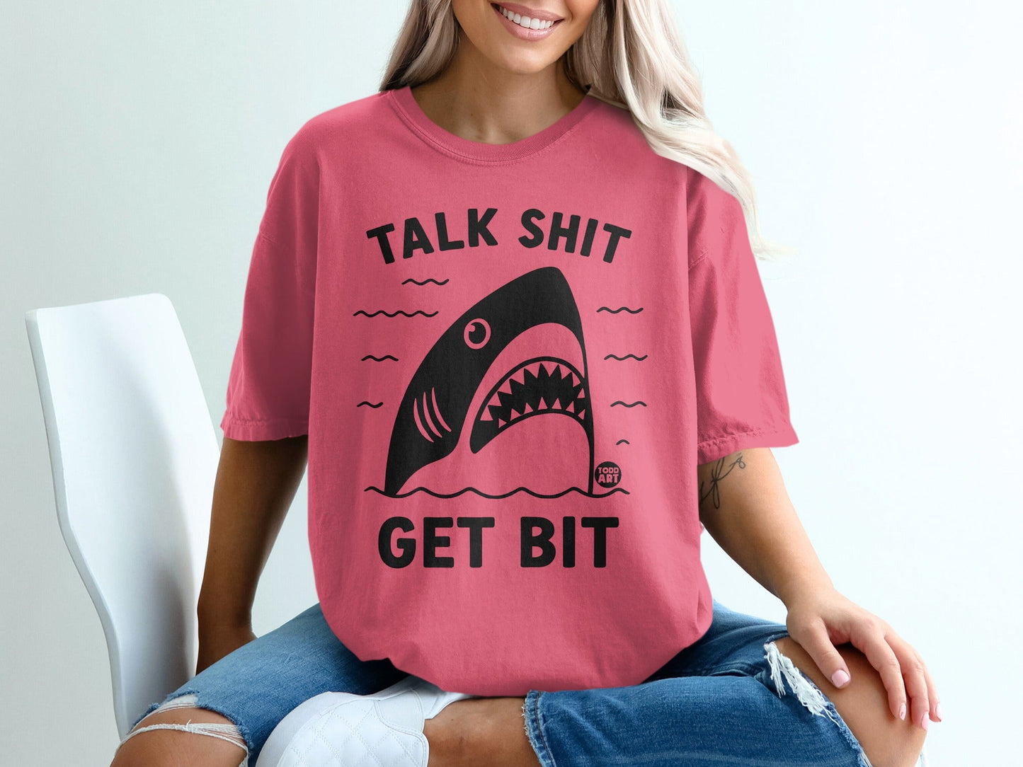 Pink t-shirt with "TALK SHIT GET BIT" and a shark graphic.
