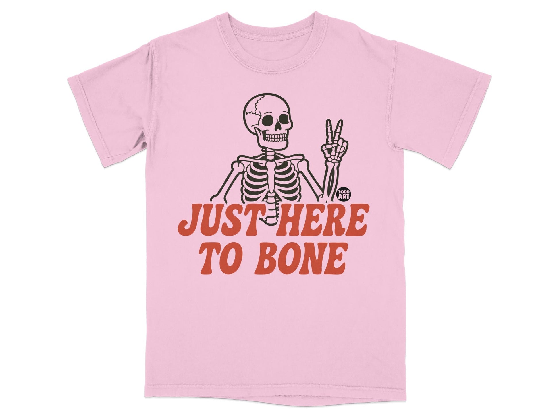 Pink t-shirt with skeleton giving peace sign and "JUST HERE TO BONE" text.