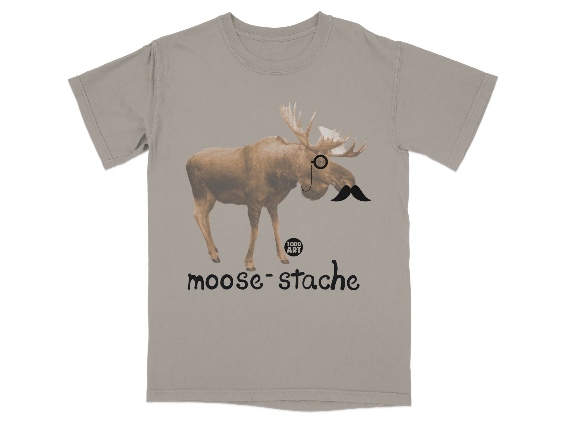 Tan t-shirt with a moose wearing a monocle and mustache, text "moose-stache".