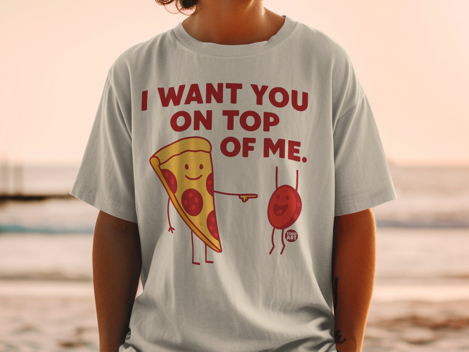 T-shirt with pepperoni pizza slice and blob characters saying "I want you on top of me."
