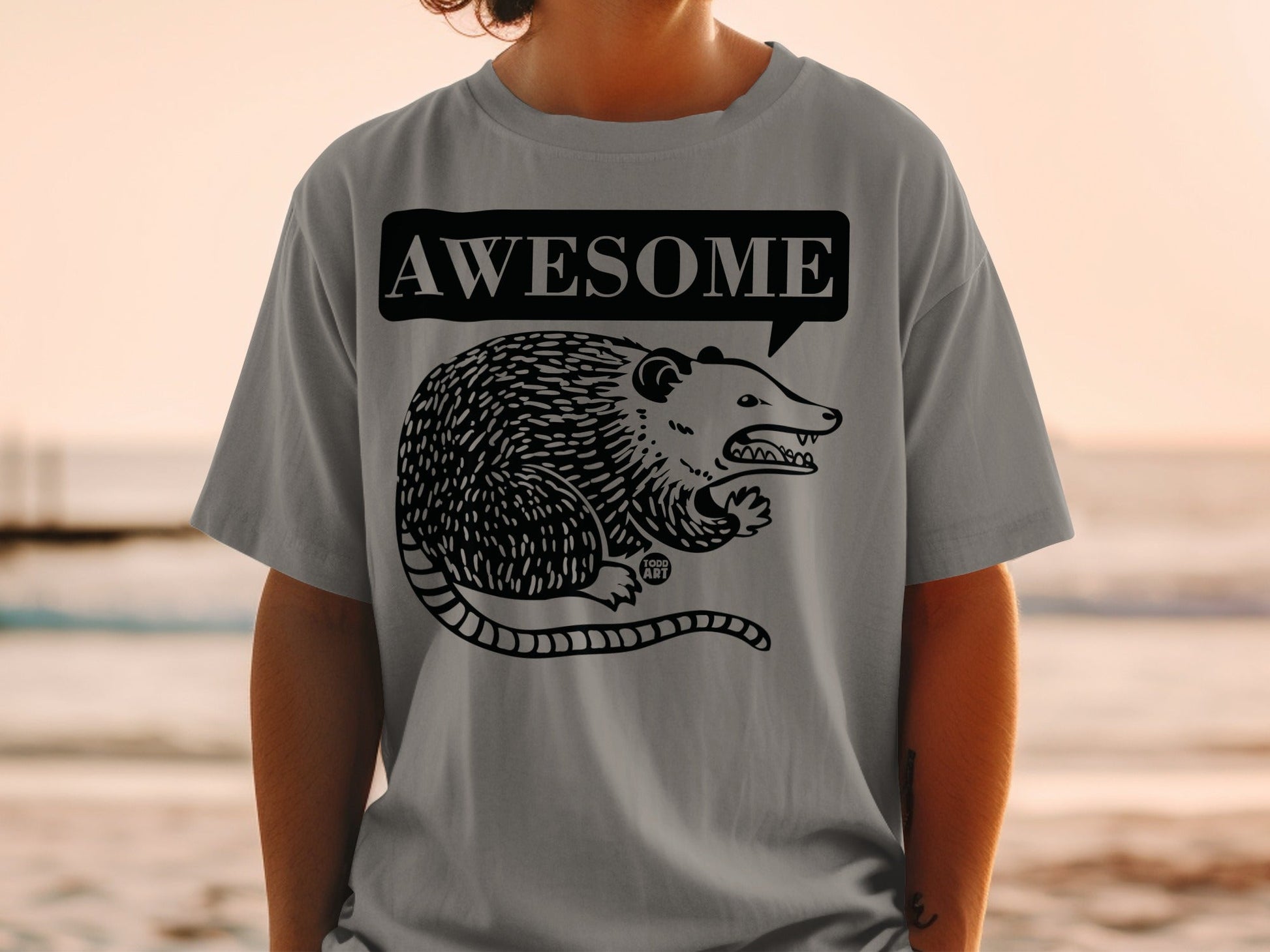 Grey t-shirt with black graphic of a possum and "AWESOME" speech bubble.