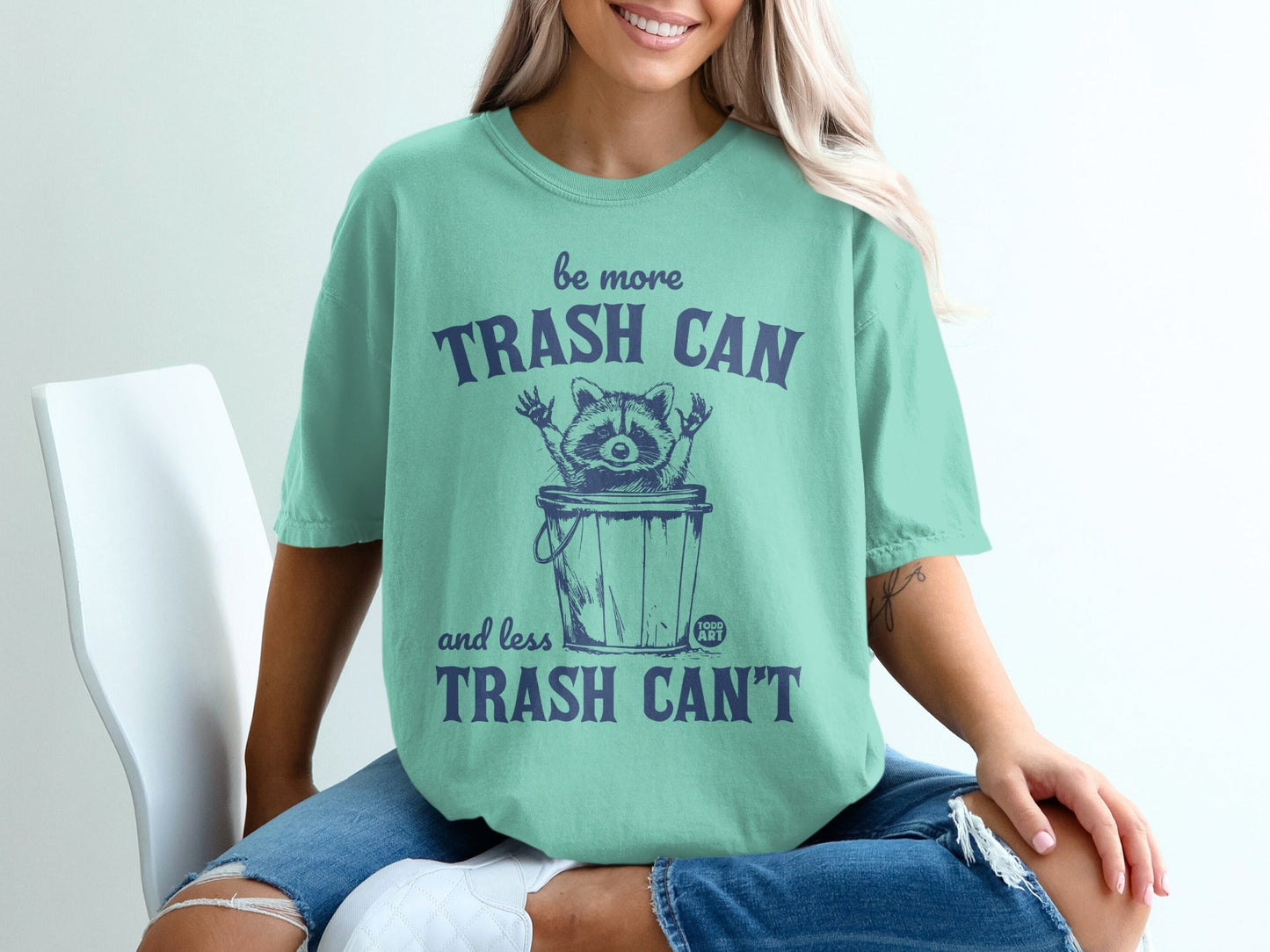 T-shirt with raccoon in trash can and text "be more trash can and less trash can't".