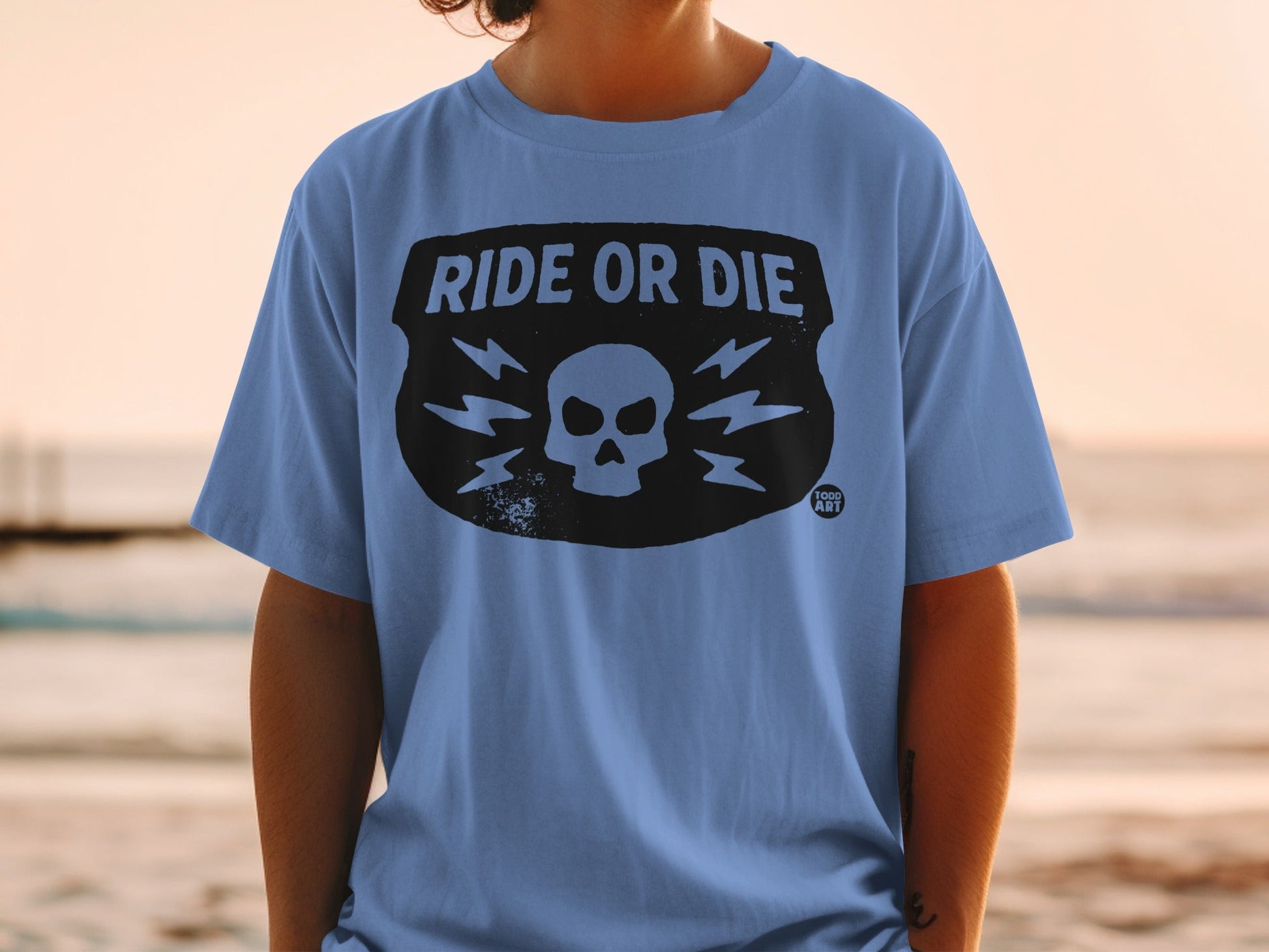Blue t-shirt with skull and lightning bolt graphic, "RIDE OR DIE" text.