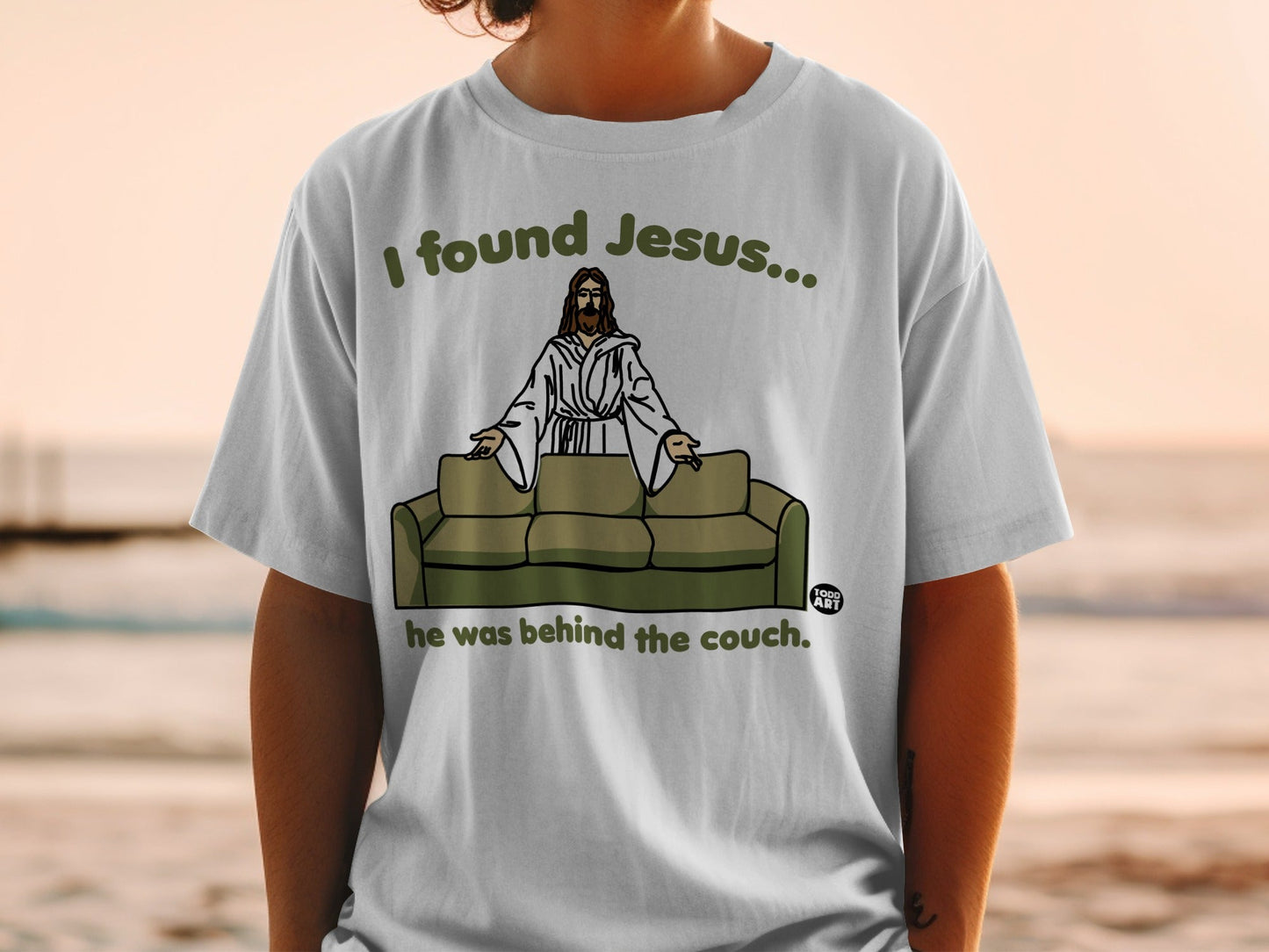 T-shirt with text "I found Jesus... he was behind the couch."